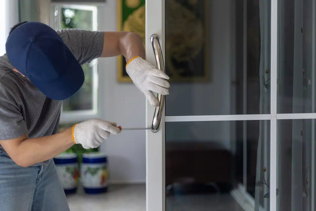 Worker install handle on aluminium swing door. cerrajero seguro de hogar